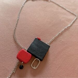 Medium length necklace central pendant black and red.